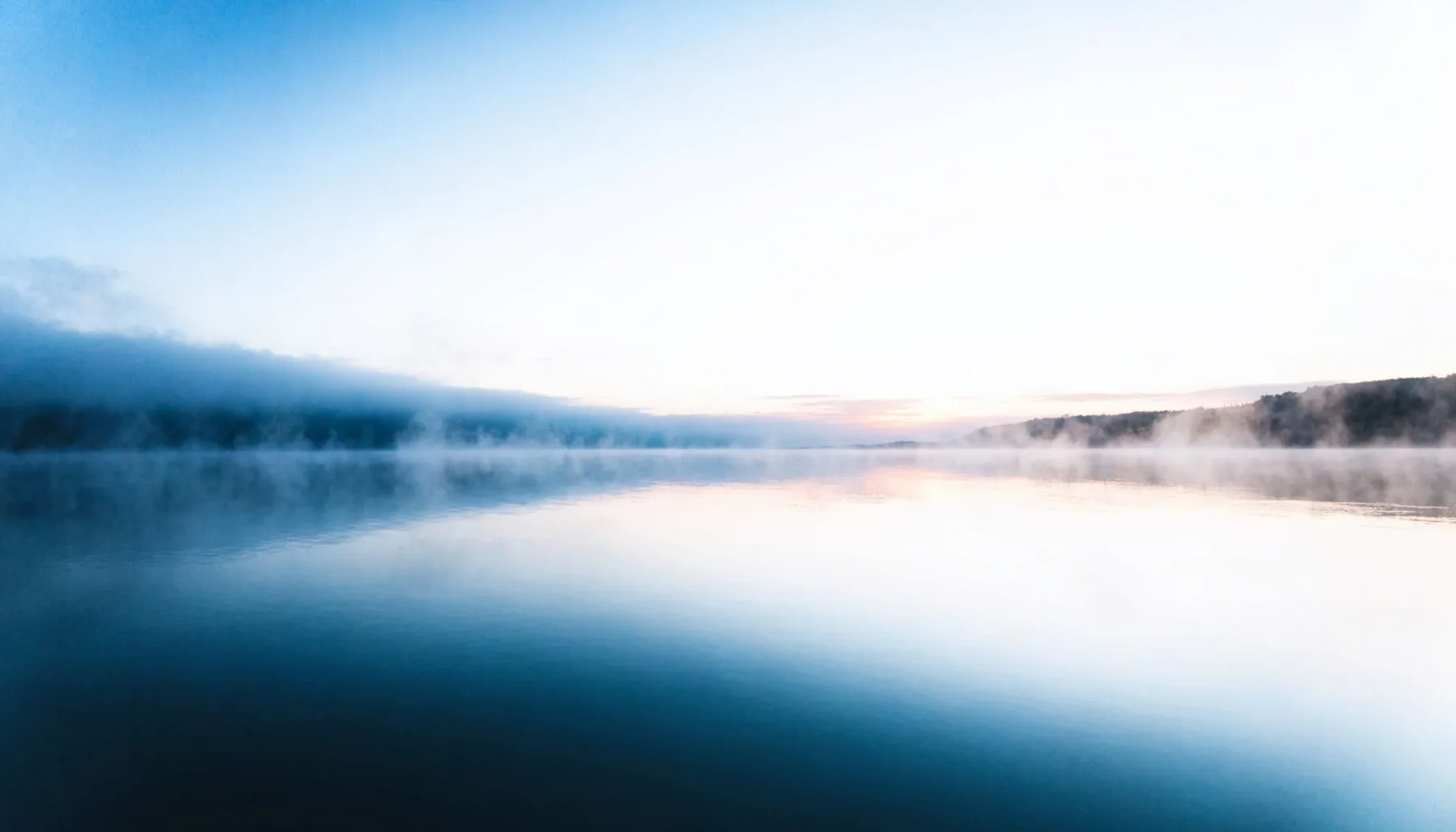Paysage apaisant aux tons bleus et blancs, lumière douce au lever du jour
